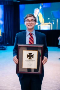 JP Hoffman standing with his plaque naming him a Thomas Arkle Clark Fellow