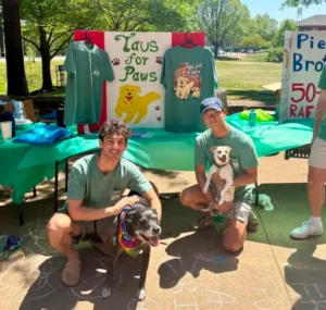 Two actives posing with dogs at the Taus for Paws fundraiser