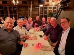 Group of 1980s Phi alumni gathered around a table at an NYC pub