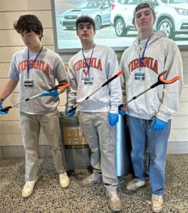 Image of Sigma Nu brothers posing with trash grabbers