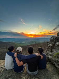 Group of actives looking at the sunrise over the mountains