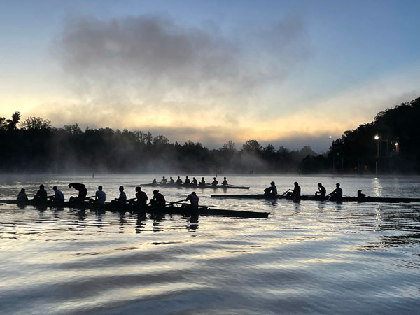 three boats on the water at sunrise